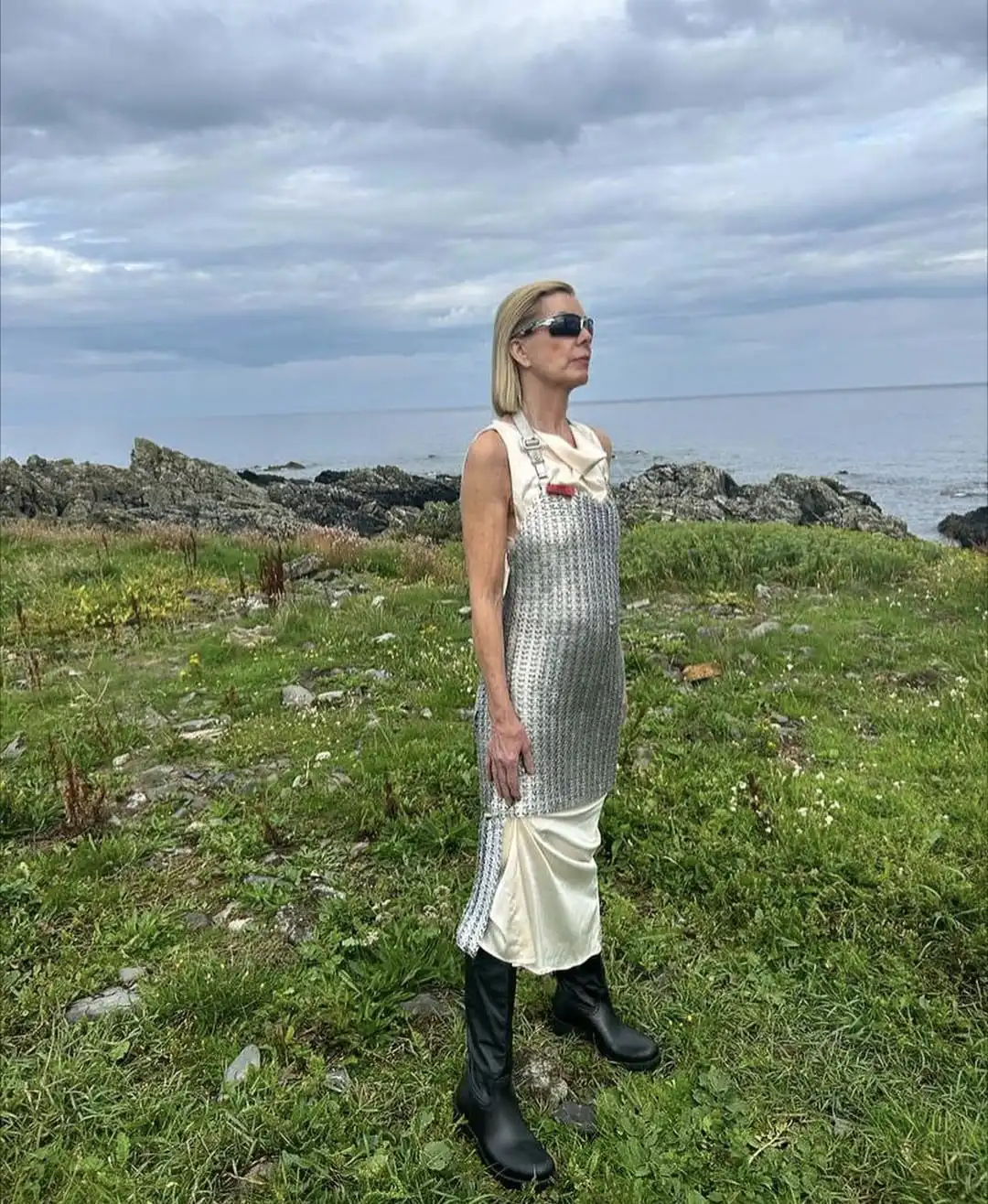 Joan dressed in a futuristic outfit posing in a field