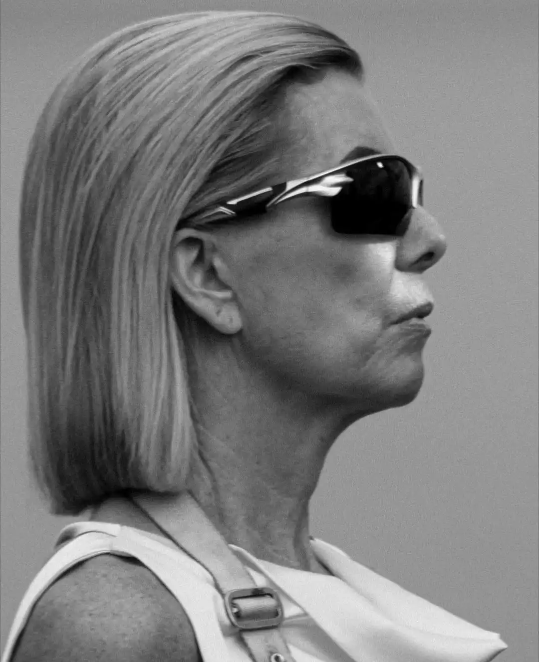Joan in profile with slicked back hair and sunglasses